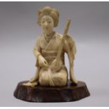 A Japanese carved ivory kneeling woman with musical instrument