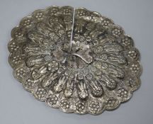 A Persian white metal oval hand mirror with repousse decoration