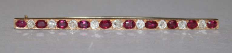 An early 20th century gold, ruby and diamond bar brooch, set with nineteen alternating graduated