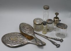 An Edwardian Art Nouveau silver mounted mirror and brush and seven other items included plated