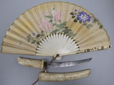 A Japanese bone tanto carved with monkeys and a Japanese polychrome and parcel gilt fan