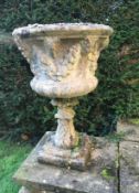 A pair of reconstituted stone garden urns, moulded with floral swags, 84cms not on view at