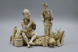 A Japanese sectional ivory okimono of two figures on a net