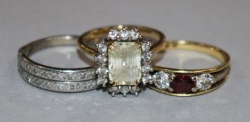 An 18ct gold, ruby and diamond three stone ring and two other gold and gem set rings.