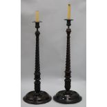 A pair of carved wooden barley twist candlesticks