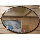 An oval brass-framed bevelled wall mirror, W.93cm