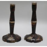 A pair of tortoiseshell and silver candlesticks