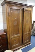 A 19th century French provincial walnut armoire, fitted a pair of doors carved with oval paterae W.