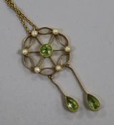 An Edwardian gold, peridot and seed pearl double drop openwork pendant, on a fine link chain,