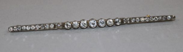 An early 20th century gold, platinum and graduated diamond bar brooch, the largest stone with an