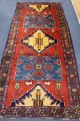 A Persian red ground rug, 10ft x 4ft 6in.