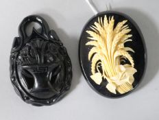 A Victorian carved ivory, Wheatsheaf and convolvulus brooch and a vulcanite brooch, approx 66mm.