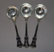 A pair of silver Edwardian silver sauce ladles by Goldsmiths & Silversmiths and a silver sifter