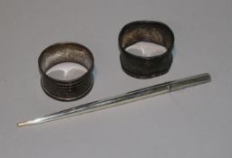 Two silver serviette rings and silver quill holder.