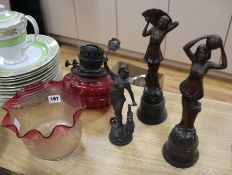 A cranberry glass shade oil lamp and three spelter figures