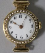 A lady's 18ct gold and split pearl set manual wind wrist watch, on a gold plated mesh bracelet.