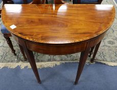 A George III mahogany demi-lune folding top card table, tulipwood-banded, W.3ft 1in.