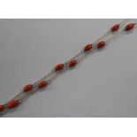 An early 20th century 9ct gold and coral bead set guard chain, gross weight 15.7 grams, 126cm.