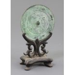 A Chinese bronze circular TLV mirror, Han dynasty or later, cast in low relief with a geometric