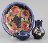 A Moorcroft pomegranate pattern dish, a tiger lily pattern small vase and a hibiscus pattern dish,