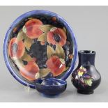 A Moorcroft pomegranate pattern dish, a tiger lily pattern small vase and a hibiscus pattern dish,