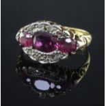 An early 20th century 18ct gold, ruby and diamond oval cluster ring, set with three rubies and