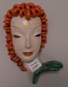 A Goldscheider painted terracotta female mask (broken at the neck) 10in.
