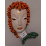 A Goldscheider painted terracotta female mask (broken at the neck) 10in.