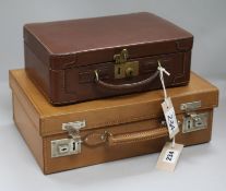 A leather-cased fitted dressing case, early 20th century, a similar smaller fitted case, both in