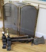 A pair of brass and cast iron fire dogs, a set of three fire brasses, a pair of bellows and a
