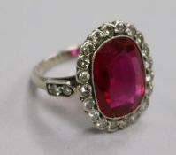 A mid 20th century platinum?, synthetic ruby and diamond set oval dress ring, size I.