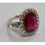 A mid 20th century platinum?, synthetic ruby and diamond set oval dress ring, size I.