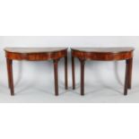 A pair of George III mahogany demi lune side tables, formerly dining table ends, with moulded