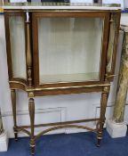 An early 19th century parcel gilt rosewood vitrine, with white marble top, on slender baluster