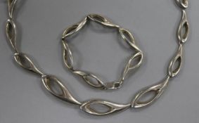 A contemporary silver necklace and matching bracelet.