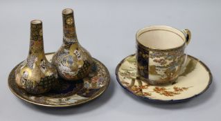 A pair of Japanese Satsuma bottle vases, a cup and two saucers