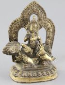 A Tibetan gilt bronze figure of Vaishravana, seated on a lion holding a mongoose on a lotus petalled