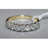 An 18ct gold and seven stone diamond half hoop ring, size R.