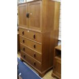 A Gordon Russell oak cupboard, enclosed by a pair of doors over four long drawers W.96.5cm