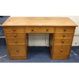 A Gordon Russell oak nine drawer desk W.130cm