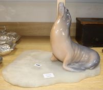 A Royal Copenhagen model of a seal, mounted on an unrelated onyx plinth H.32cm