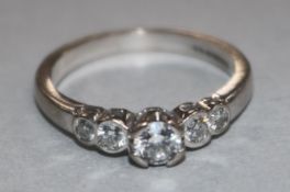 An 18ct gold and graduated five stone diamond half hoop ring, size L.