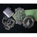 An Edwardian silver nurse's buckle, a silver vesta, a silver albert and a silver photograph frame.