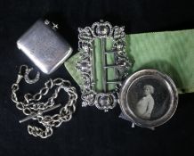An Edwardian silver nurse's buckle, a silver vesta, a silver albert and a silver photograph frame.