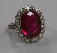 A mid 20th century platinum?, synthetic ruby and diamond set oval dress ring, size I.