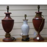 A pair of red and black toleware lamps and another 49cm, 37cm