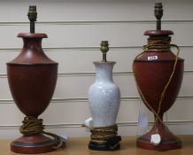 A pair of red and black toleware lamps and another 49cm, 37cm