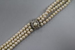 A triple strand cultured pearl choker necklace with 9ct white gold and gem set clasp, 30cm.