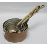 A set of graduated copper saucepans