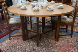 A Gordon Russell oak circular drop leaf dining table with gate leg action underframe Top 143cm